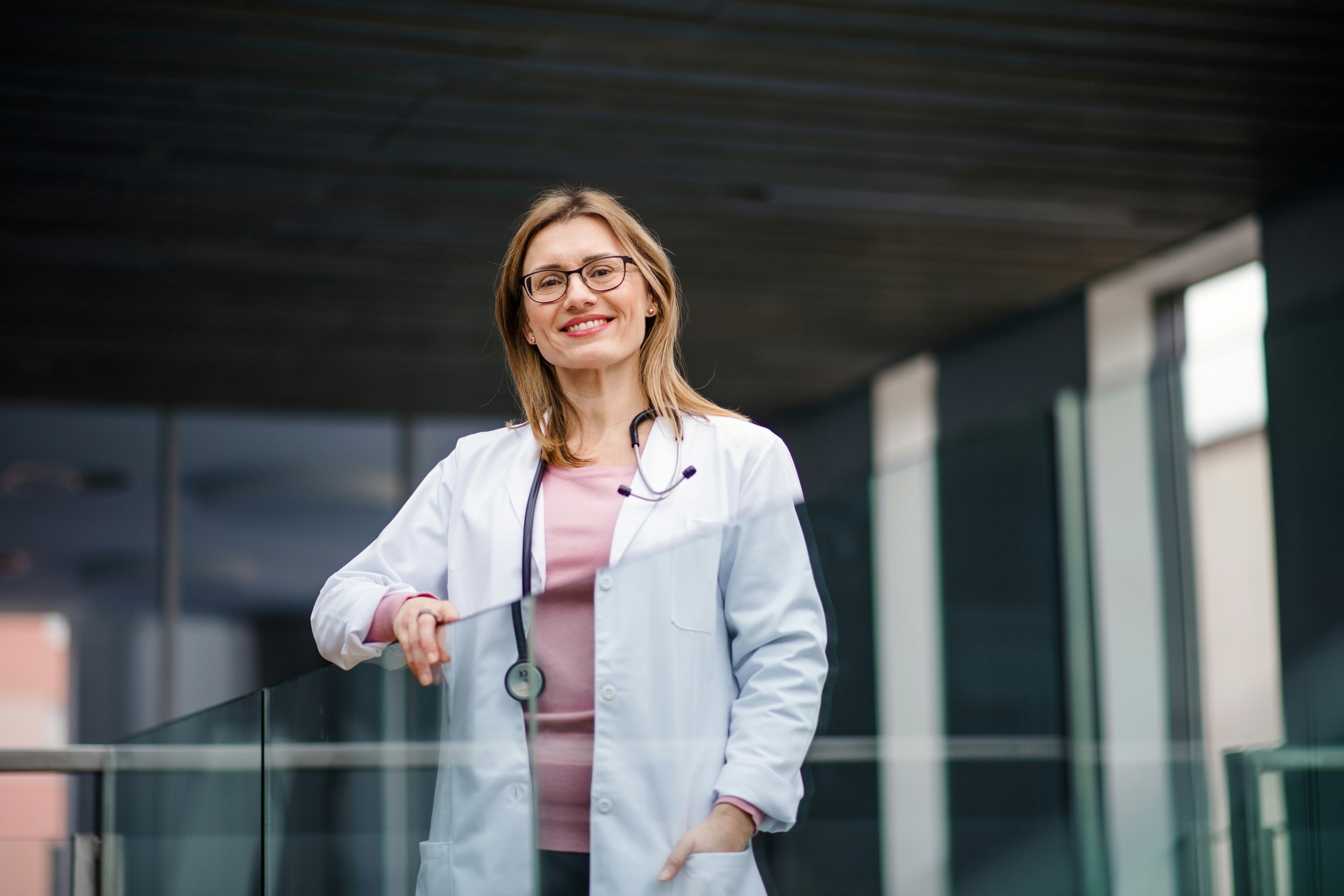 Woman in a white coat on a balcony